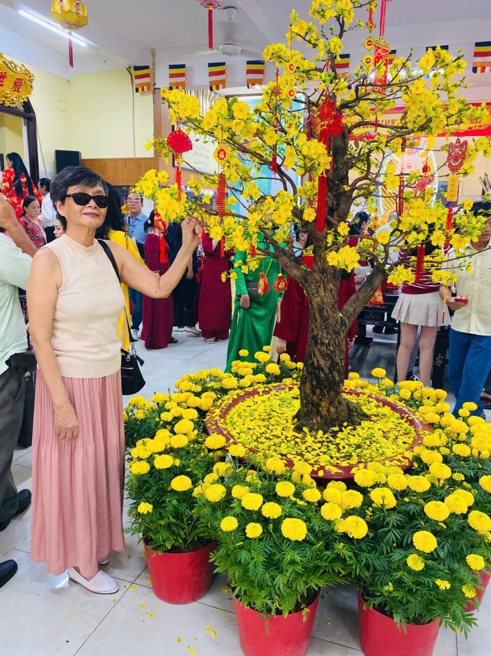 Người phụ nữ Huế bên hoa mai vàng